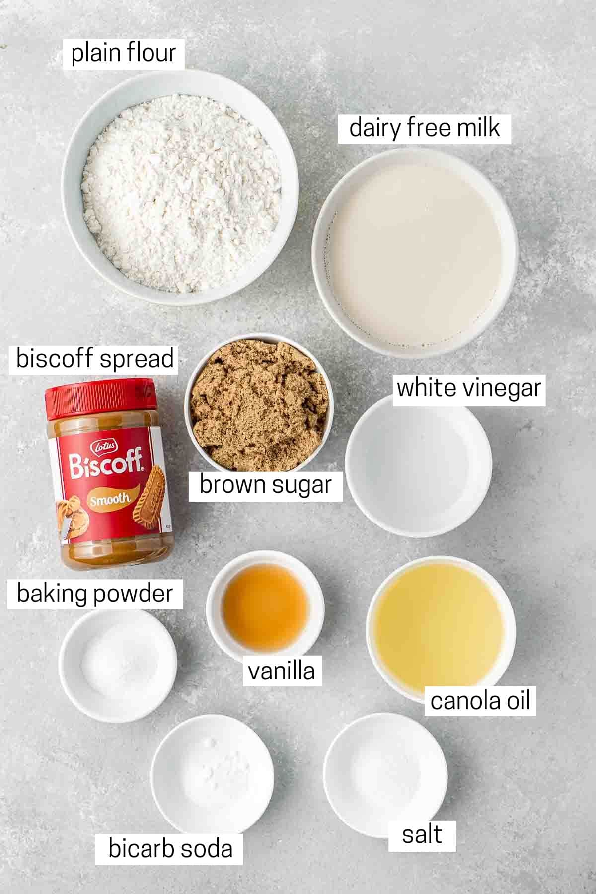 All ingredients needed to make vegan biscoff cupcakes laid out in small bowls.