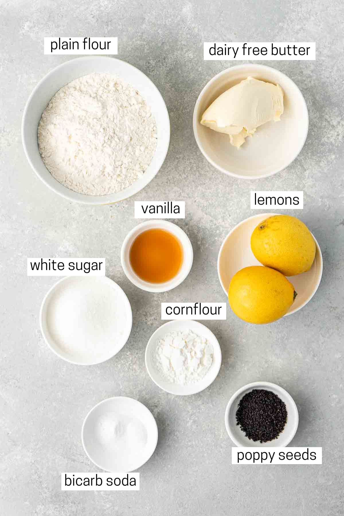 All ingredients needed to make vegan lemon poopy seed cookies laid out in small bowls.