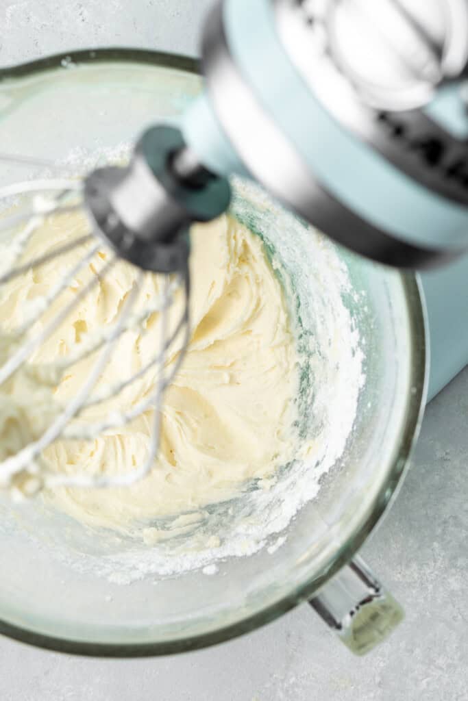 Beating together butter and icing sugar in a stand mixer.