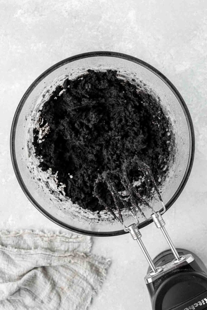 Beating together the cookie dough in a glass bowl.