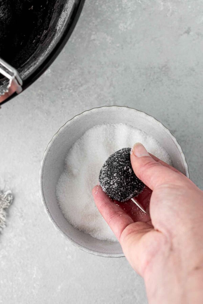 Rolling balls of cookie dough in sugar.