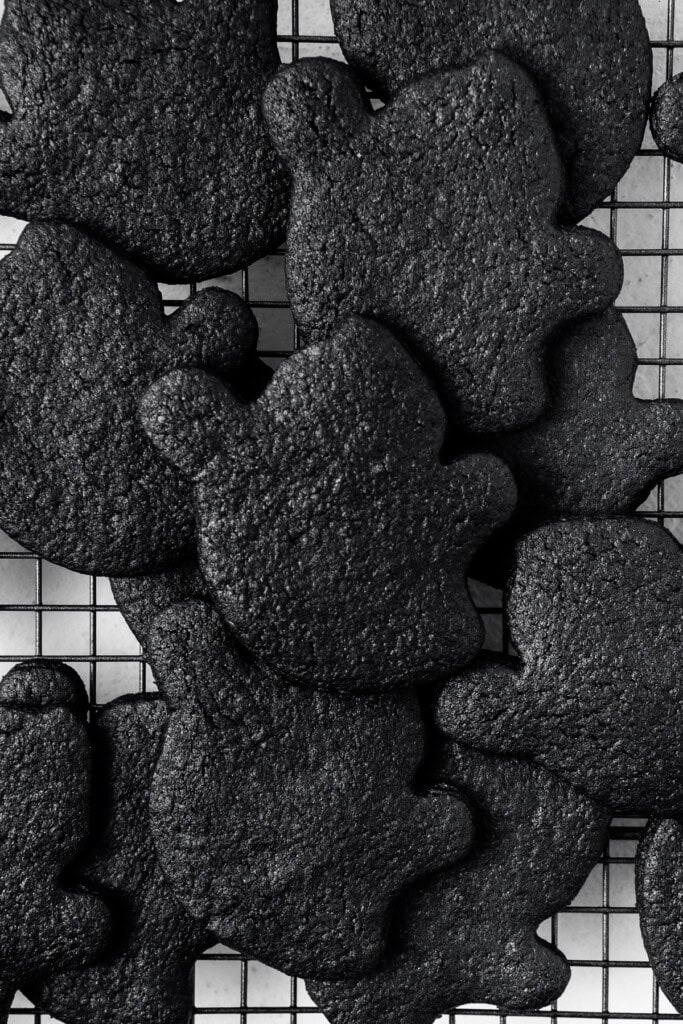 Cooked black cocoa ghost cookies on a cooling rack.