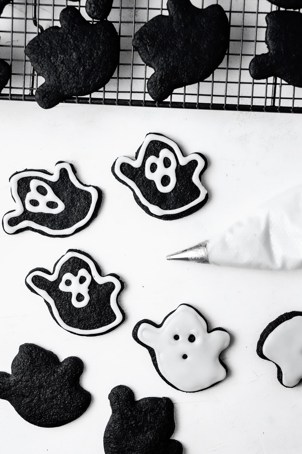 Decorating the black ghost cookies with royal icing.