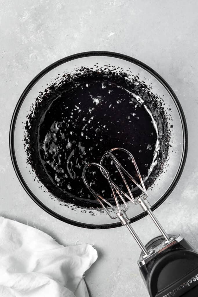 Mixing together the black cupcake batter in a mixing bowl.