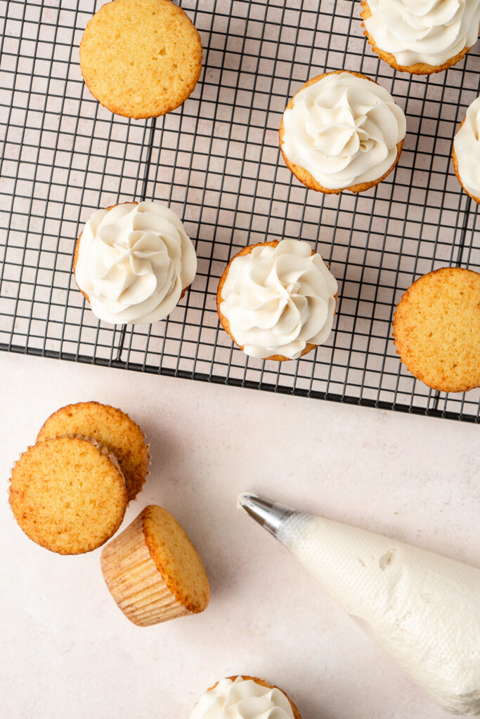 Piping icing onto cupcakes.