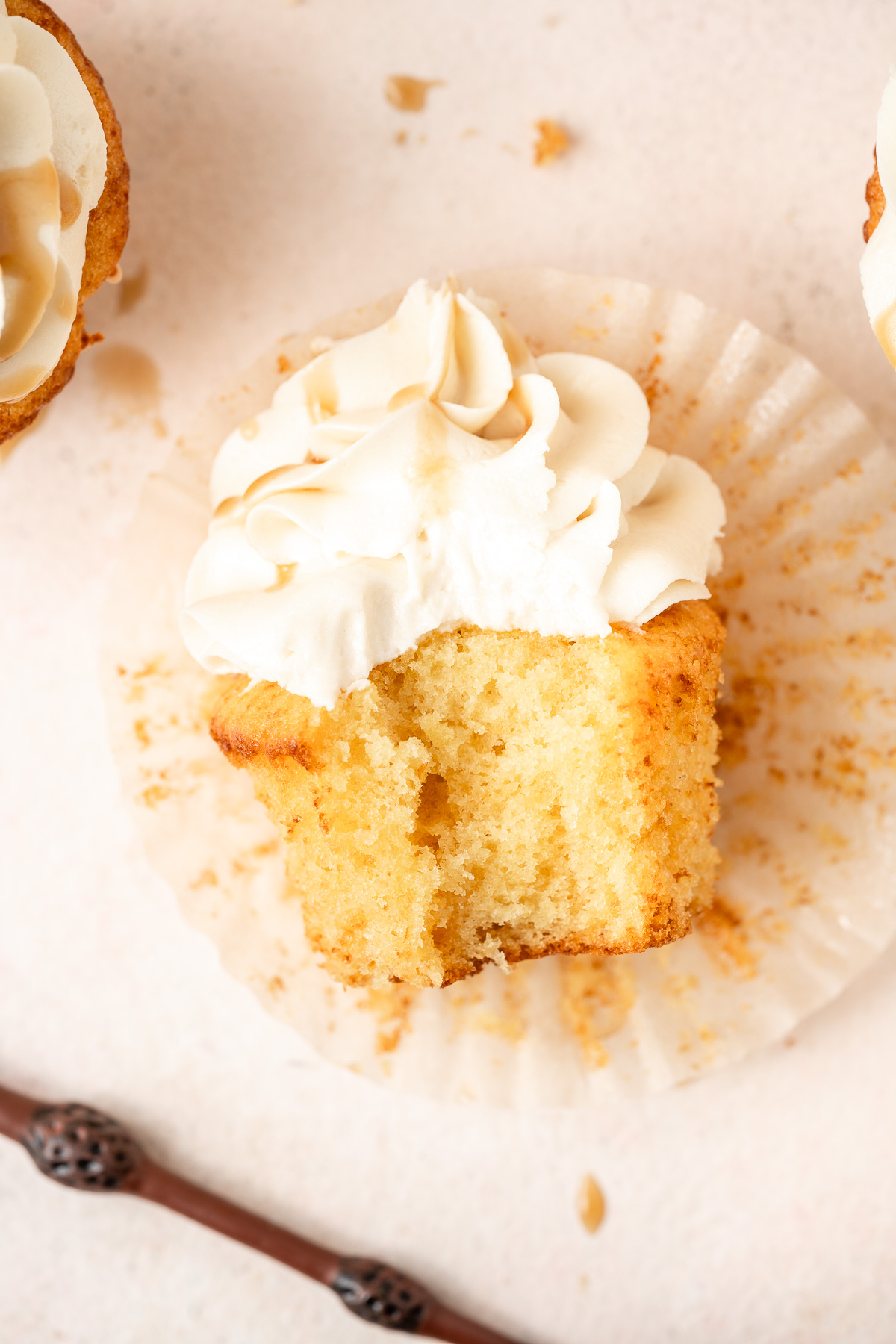 Close up of a butterbeer cupcake with a bite taken.