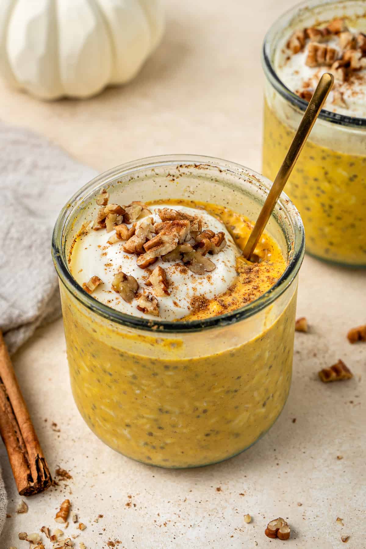 Pumpkin pie overnight oats in a jar topped with yoghurt and pecans. 