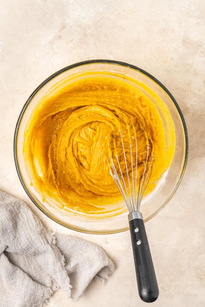 The vegan pumpkin bread batter in a bowl with a whisk.