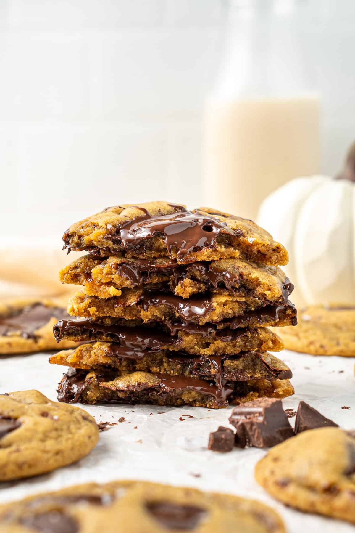 Stack of chocolate chip cookies in half with chocolate oozing. 