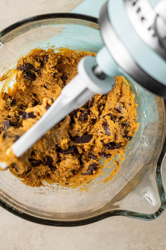 Pumpkin chocolate chip cookie dough in a stand mixer.