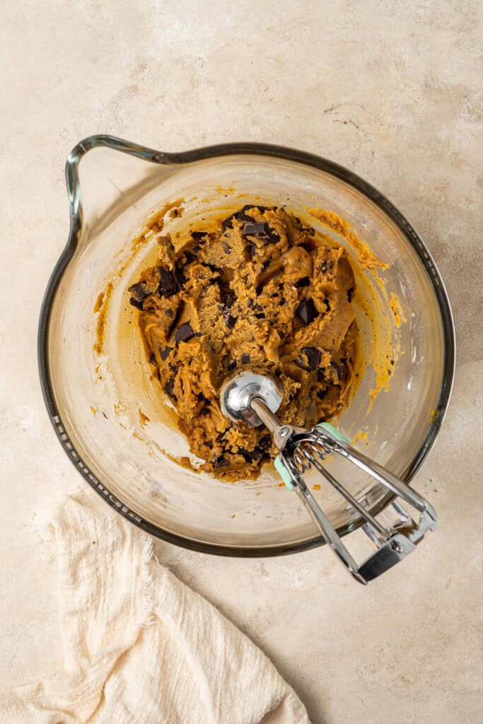 Chilled cookie dough in a bowl with a scoop.