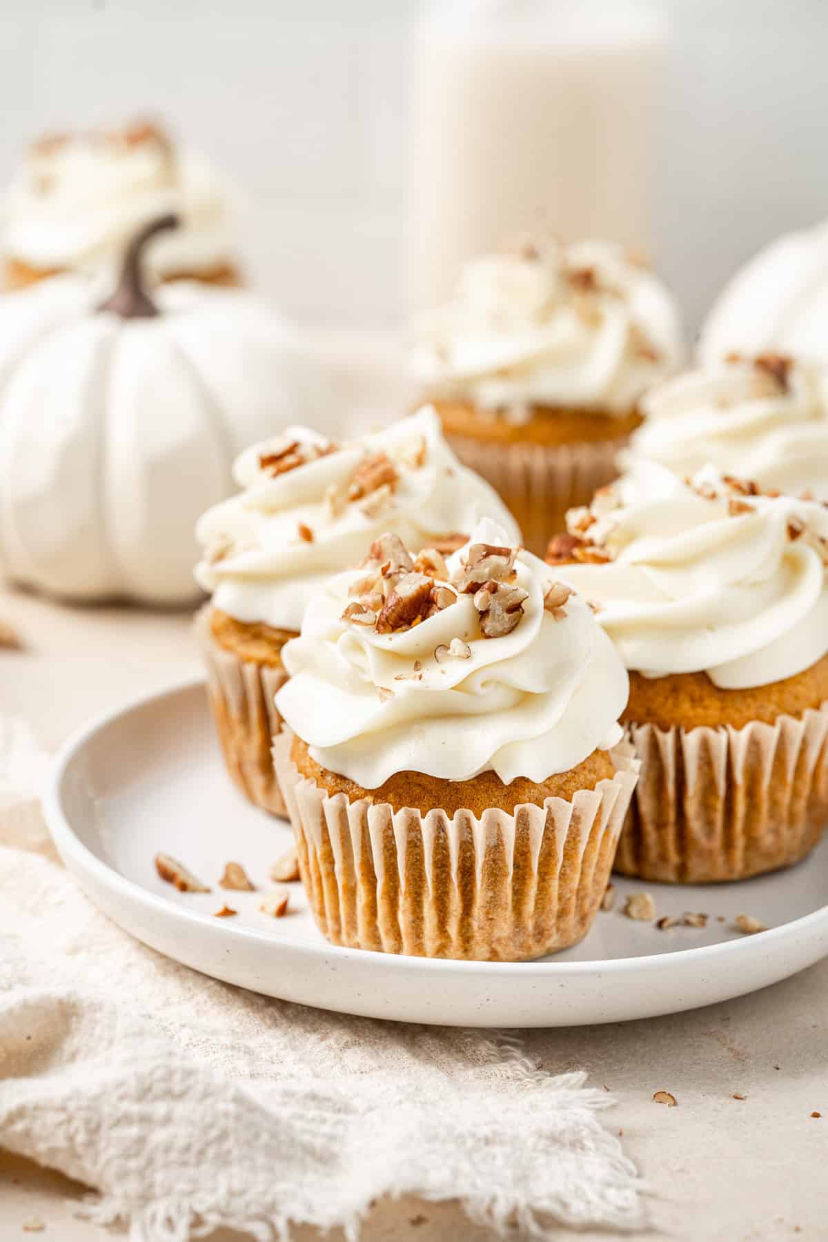 Three pumpkin cupcakes on a plate.