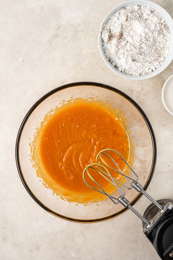 Mixing together the wet and dry ingredients in bowls.