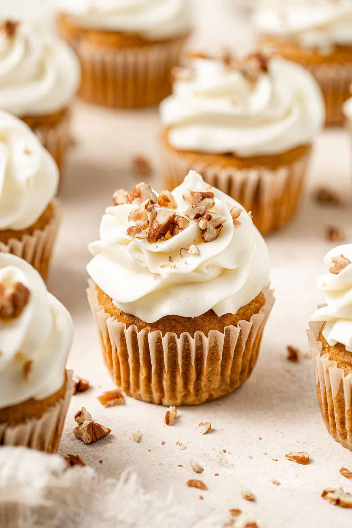 Vegan pumpkin cupcake with cream cheese frosting and pecans.