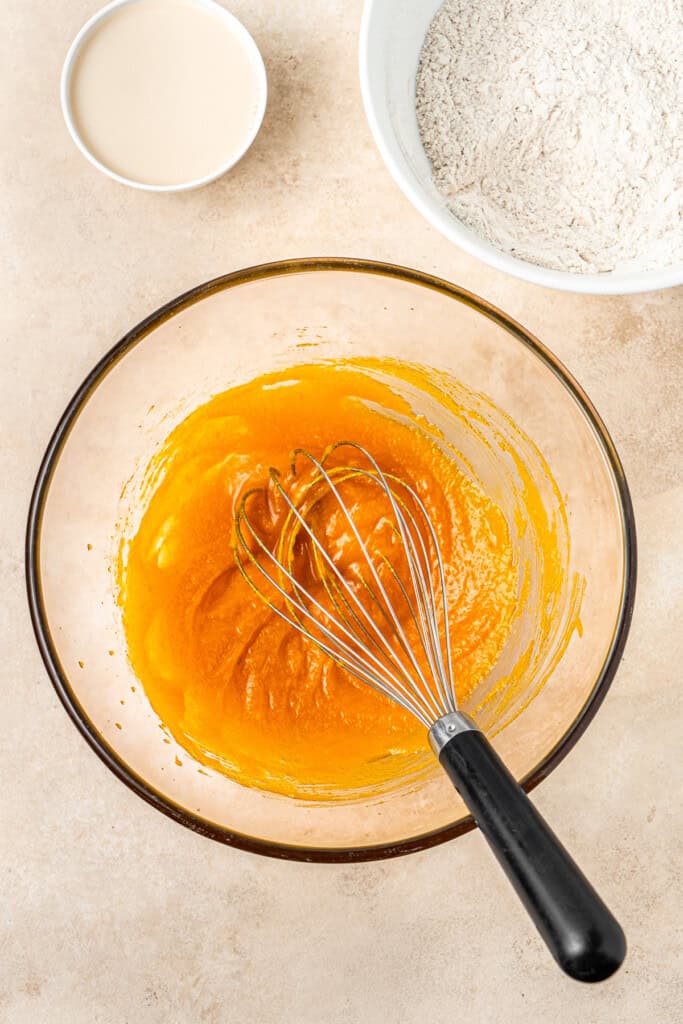 Whisking together the wet ingredients in a glass bowl.