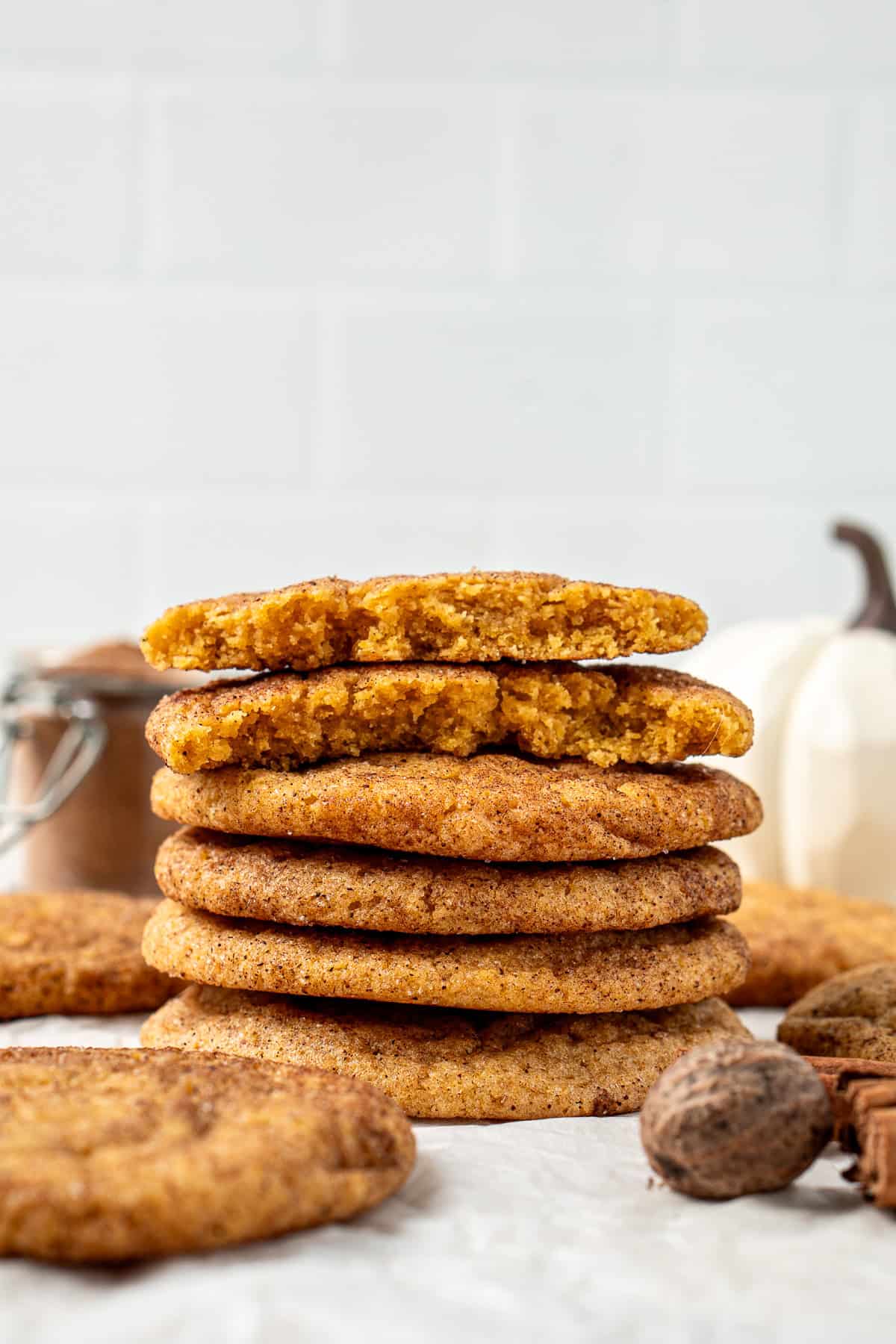 Stack of vegan pumpkin snickerdoodles with the top one broken in half.