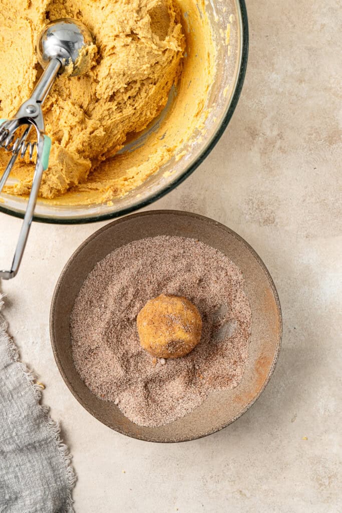 Rolling balls of cookie dough in the spiced sugar mixture. 