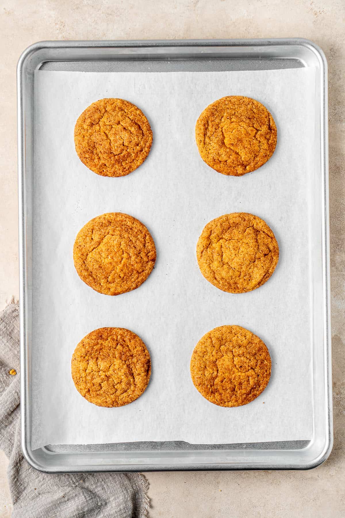 Freshly baked pumpkin snickerdoodles on a baking tray.