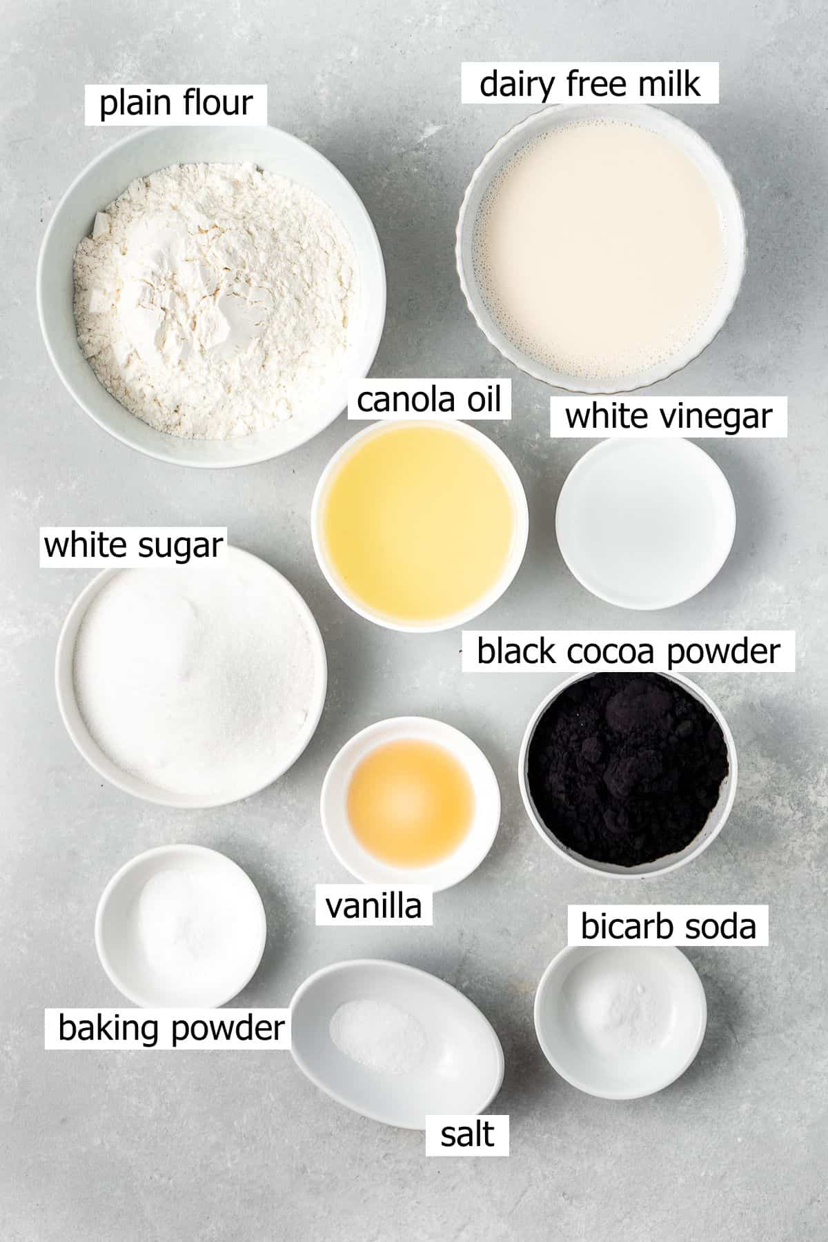 All ingredients needed to make black  velvet cupcakes laid out in small bowls.