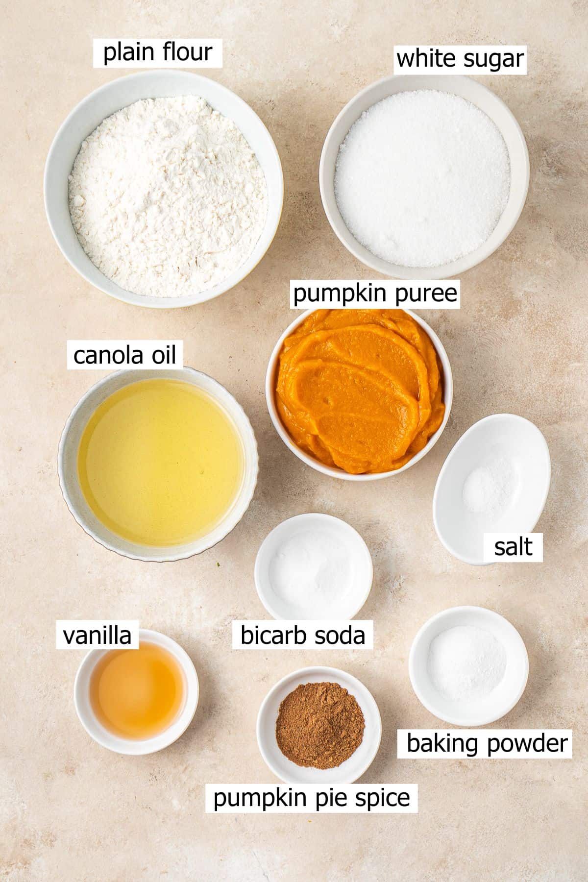 All ingredients needed to make vegan pumpkin bread laid out in bowls.