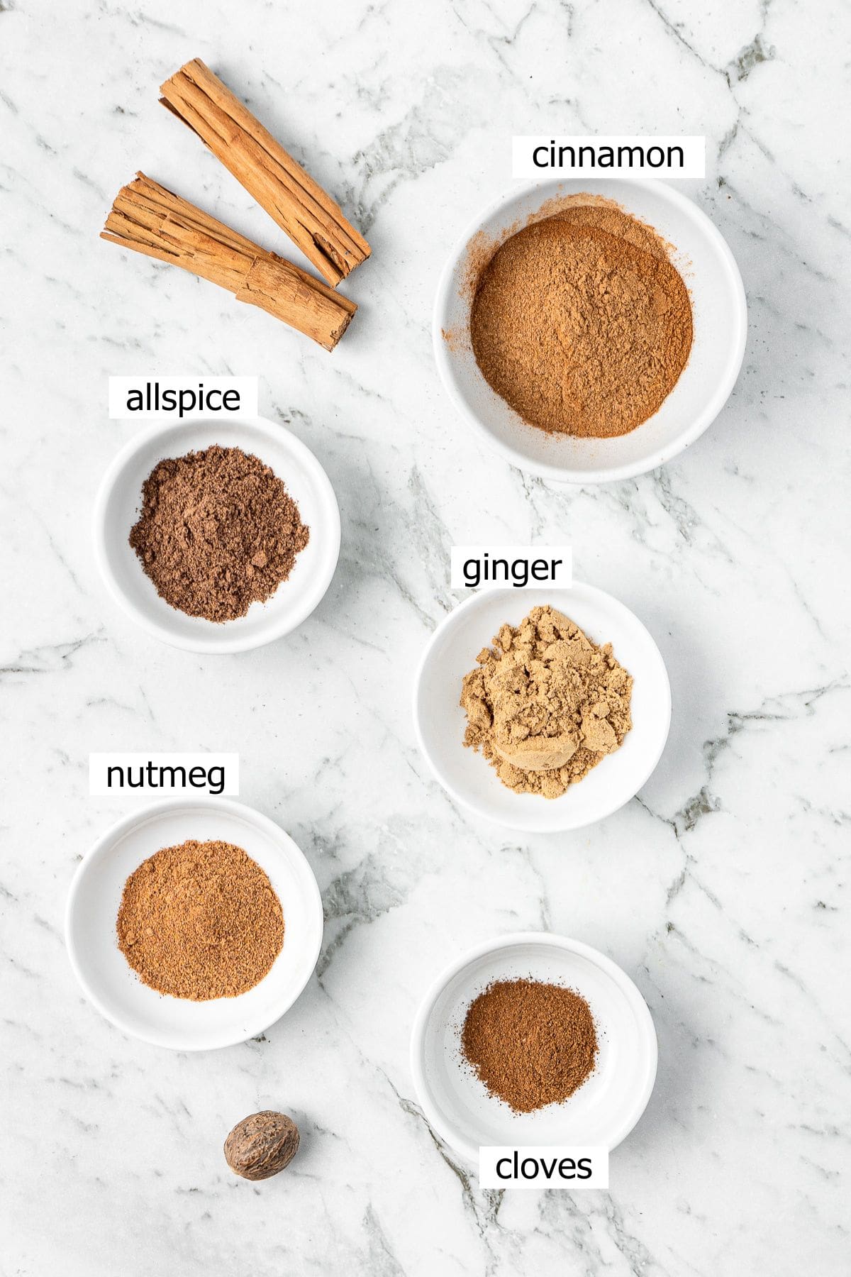 All ingredients needed to make pumpkin pie spice mix laid out in small bowls.