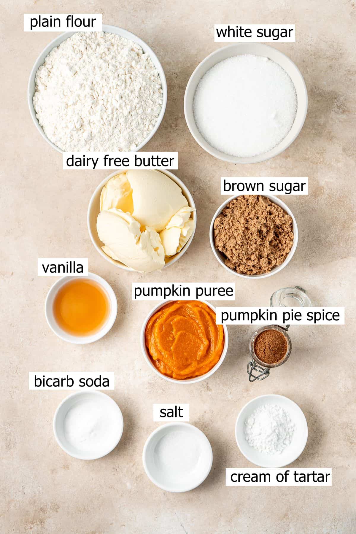 All ingredients needed to make vegan pumpkin snickerdoodles laid out in small bowls.