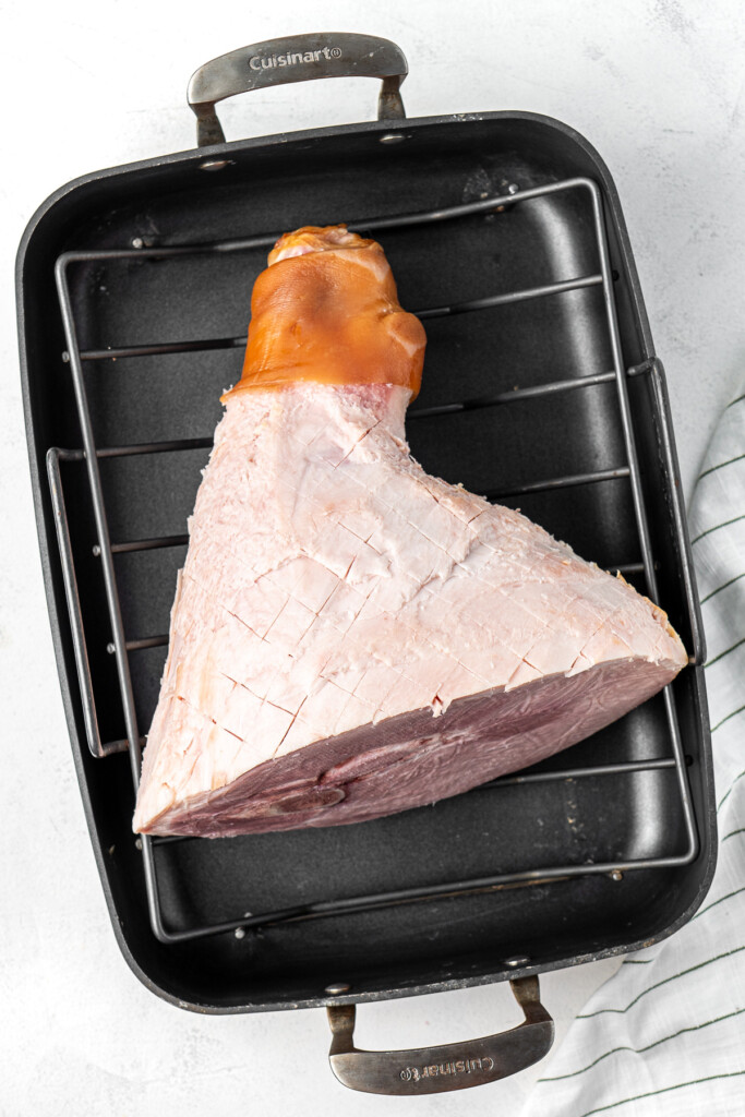 Ham with the skin removed and fat scored in a baking tray.