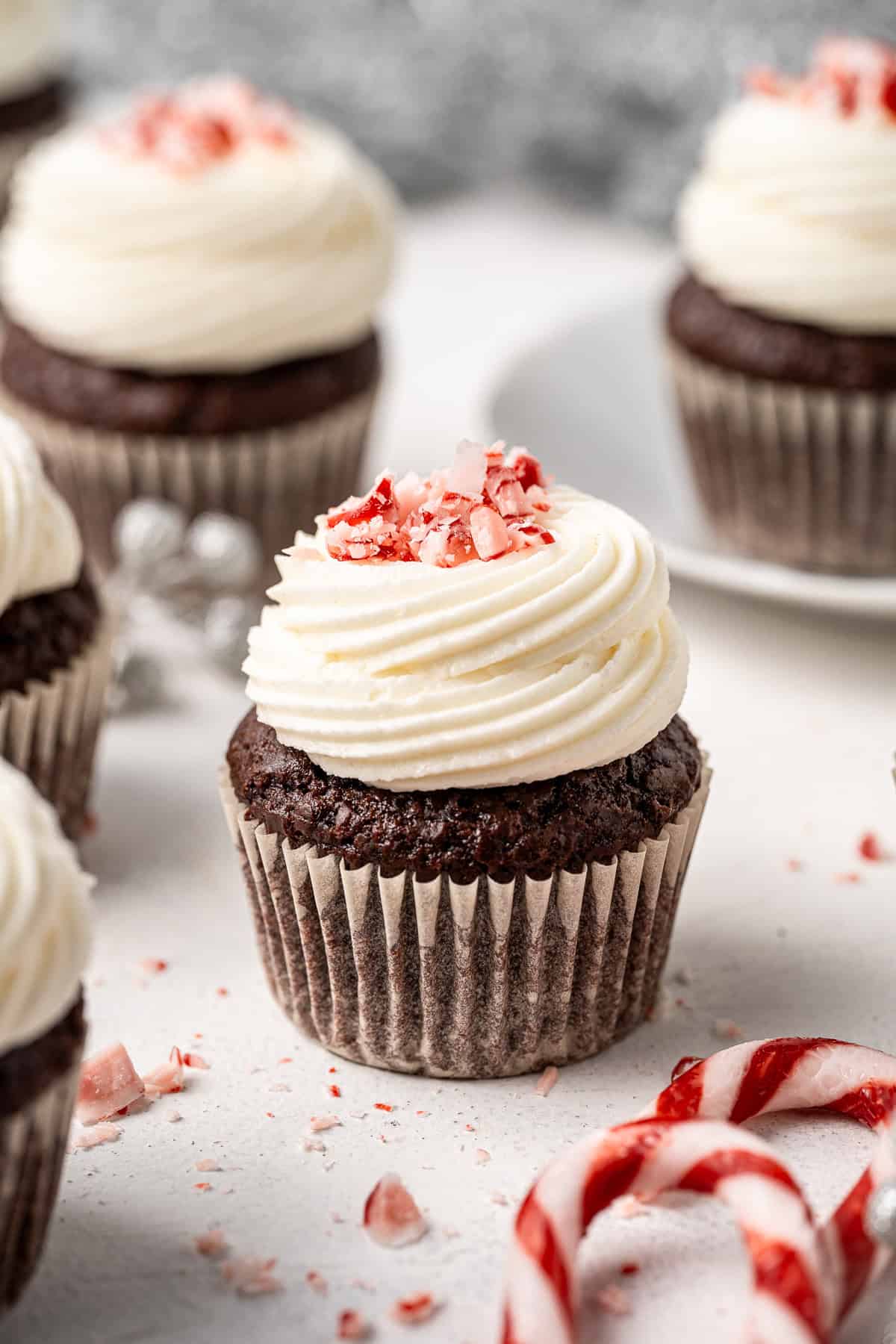 Close up of a vegan chocolate cupcake with peppermint buttercream and crushed candy canes.