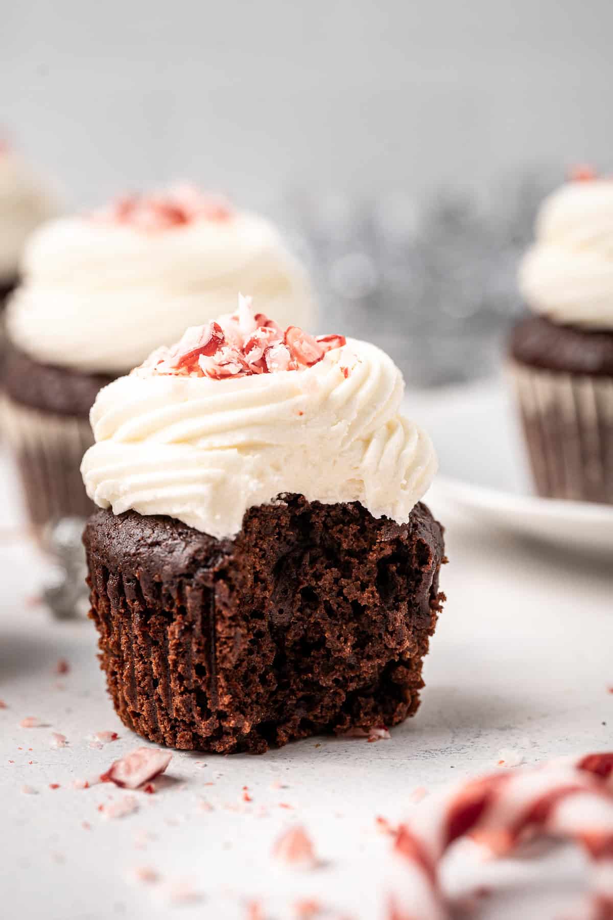 Close up of a chocolate peppermint cupcake with a bite taken.