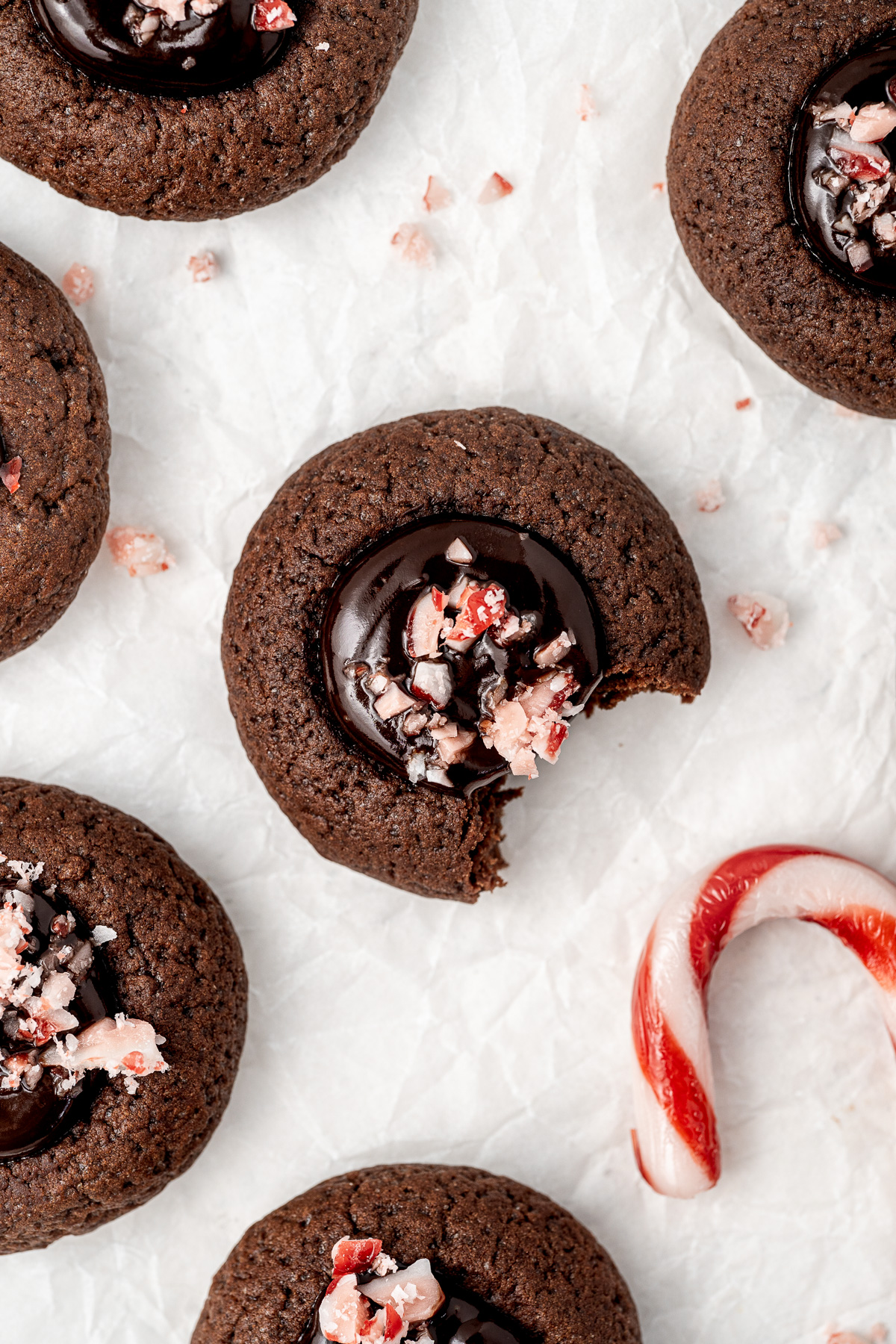 Overhead of chocolate peppermint thumbprint cookies with crushed candy canes.