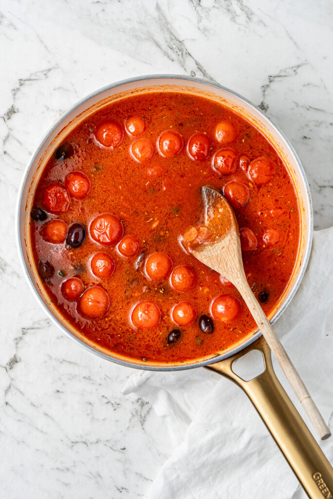 The puttanesca sauce ready to be cooked down in a frying pan.