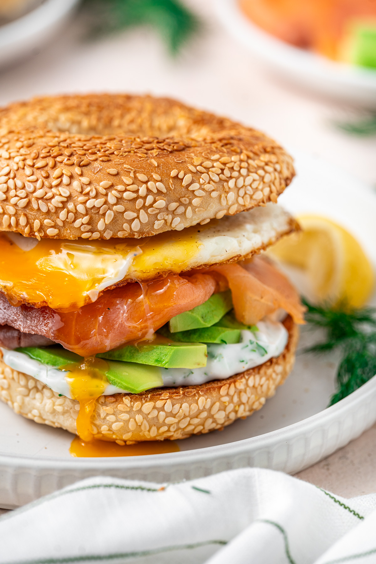 Close up of the smoked salmon breakfast bagel with runny egg yolk drip.