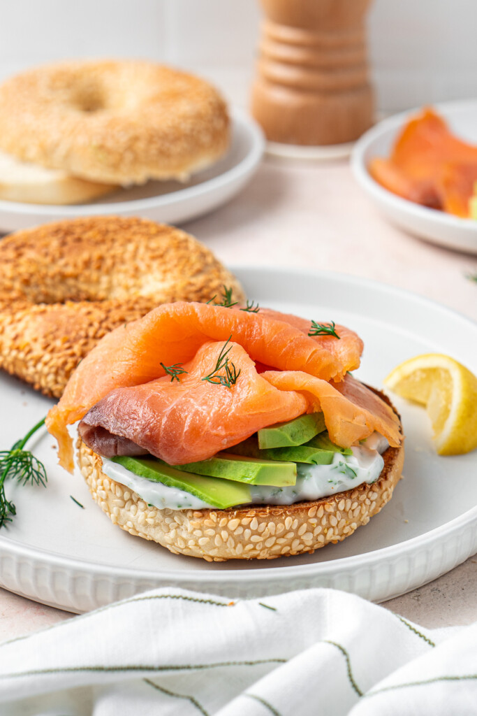 The smoked salmon layered onto the avocado bagel.