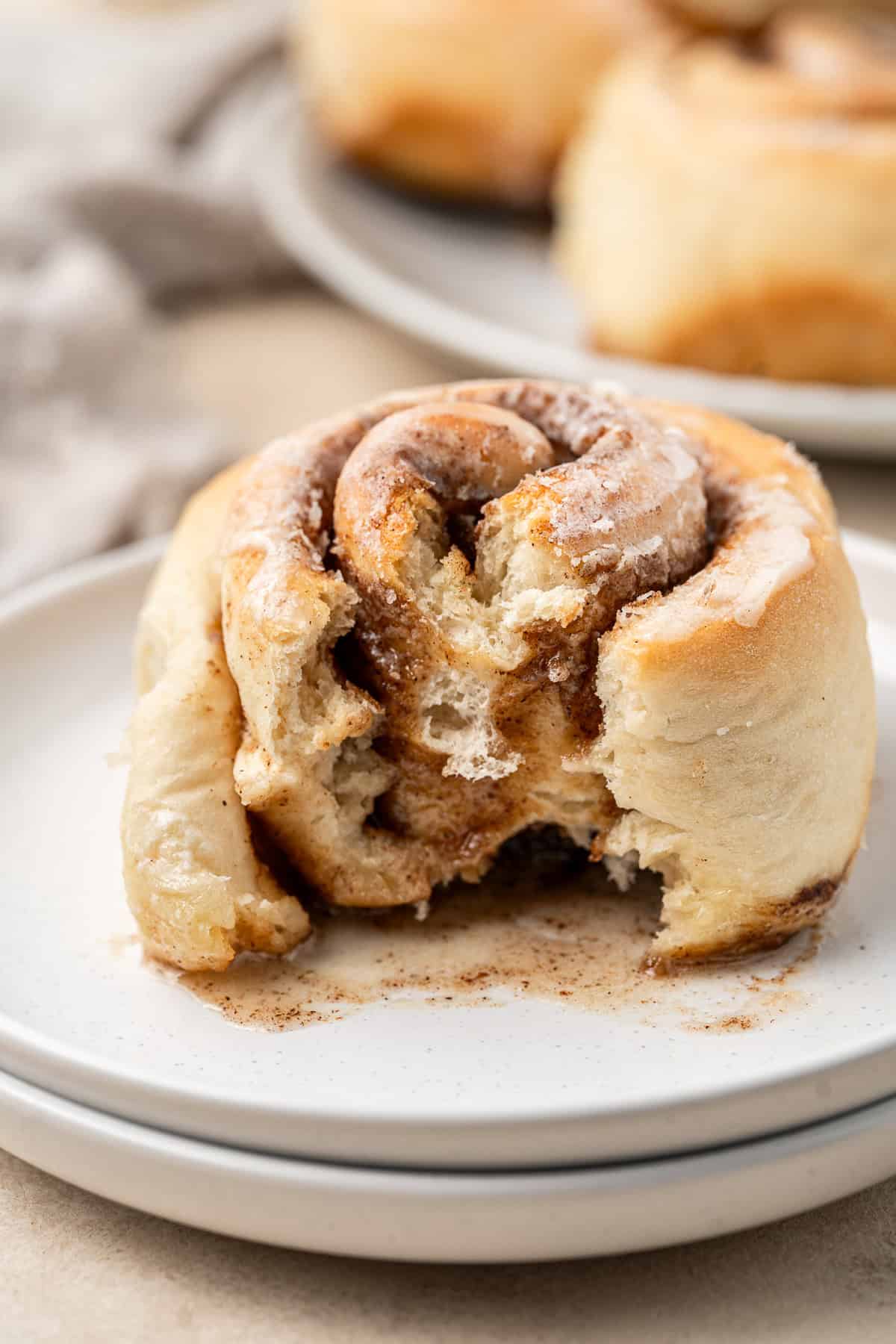 Close up of a dairy free cinnamon roll with a bite taken.