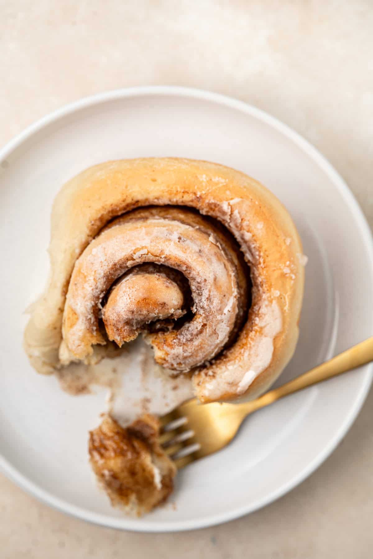 A single cinnamon roll on a plate.