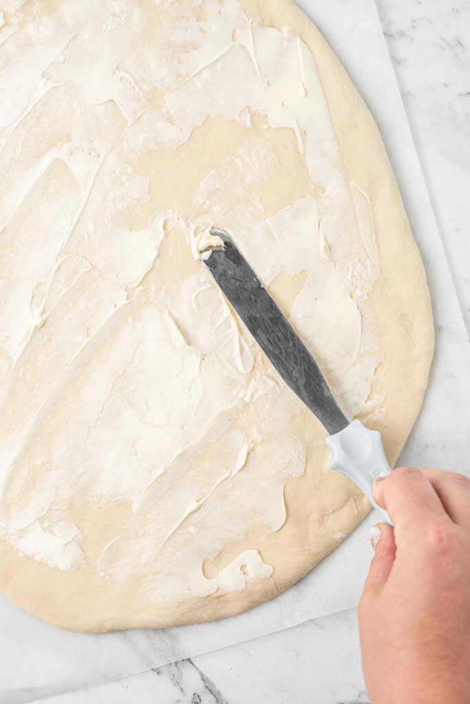 Spreading out the dairy free butter over the dough.