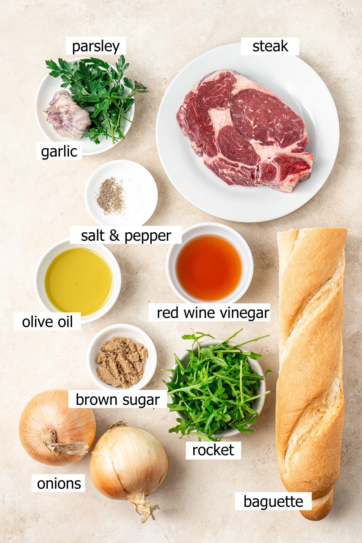 All ingredients needed to make steak crostini with caramelised onions and chimichurri laid out in bowls.