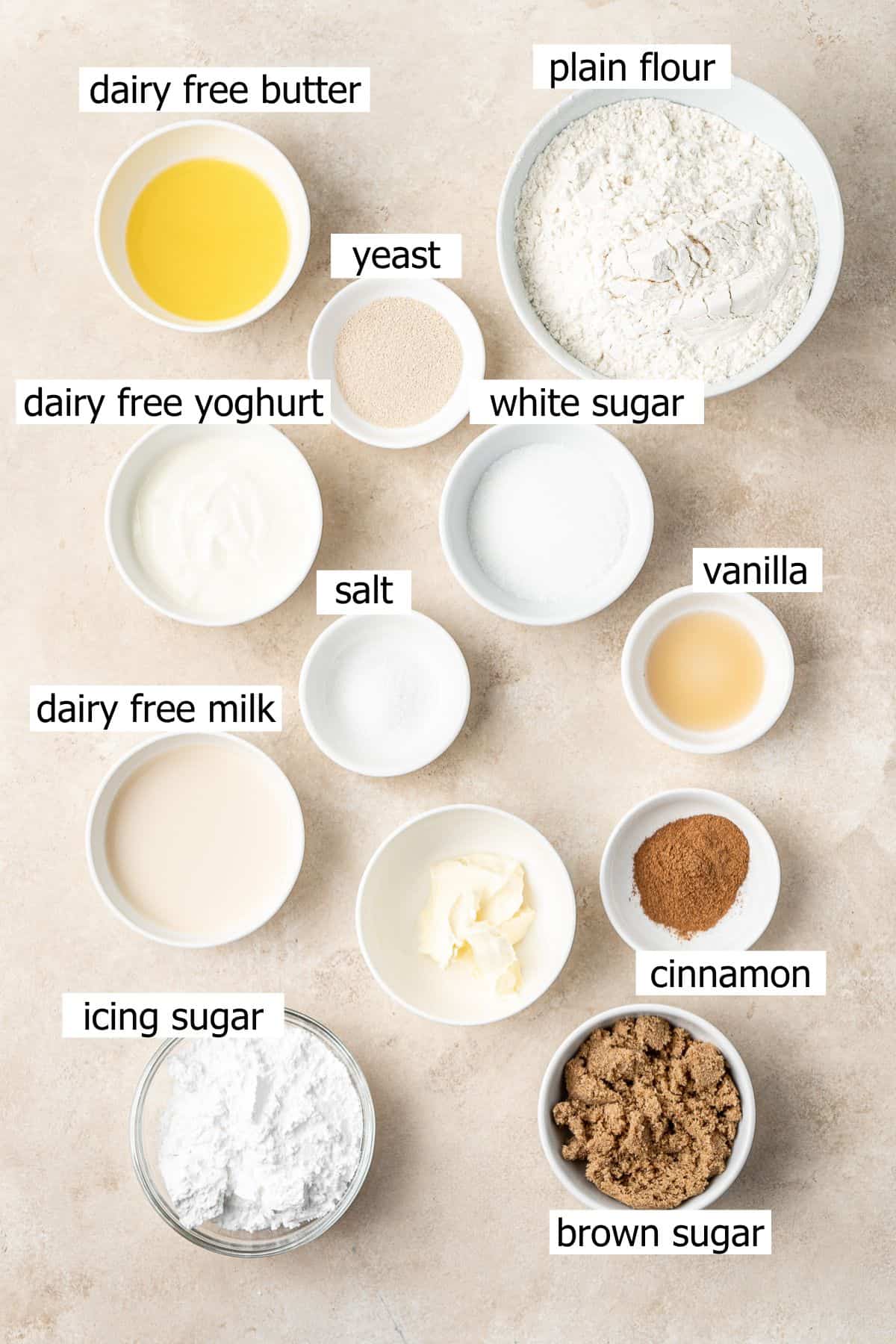 All ingredients needed for vegan cinnamon rolls laid out in bowls.