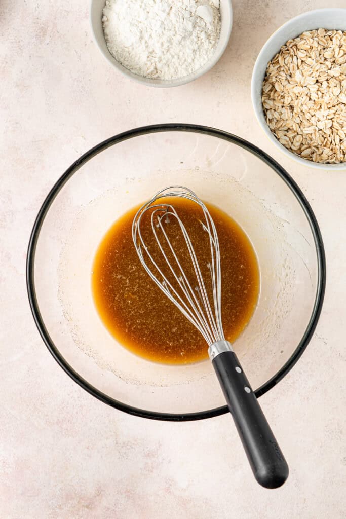 Whisking the wet ingredients in a glass mixing bowl.