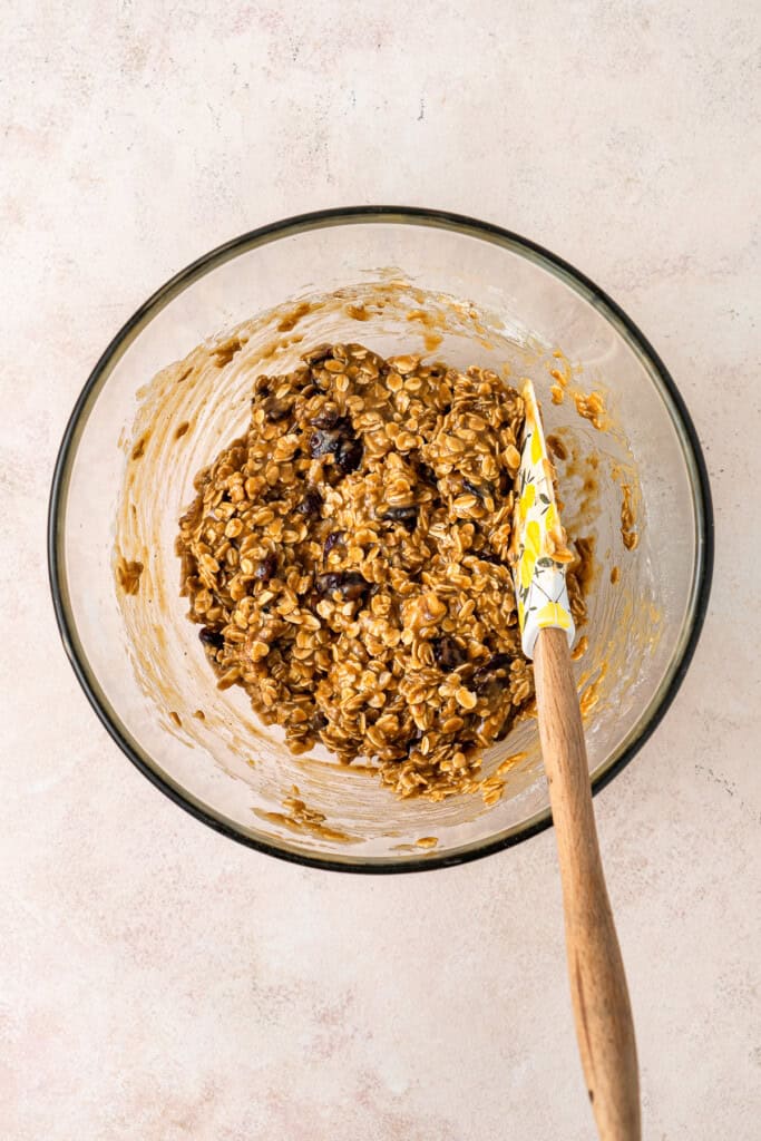 The cookie dough in a mixing bowl with a spatula.