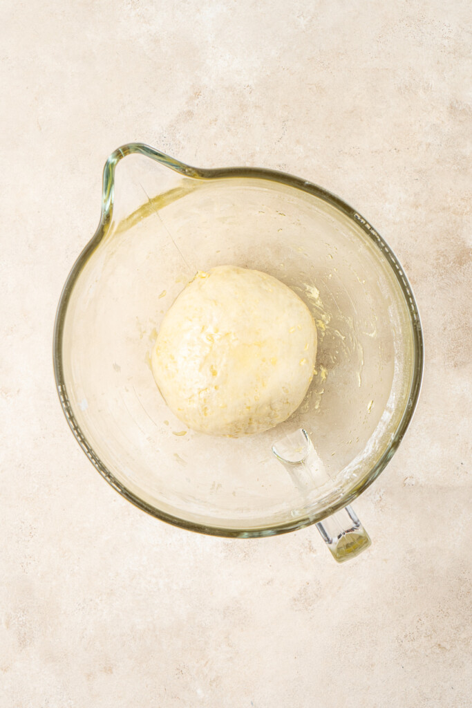 The dough in the bowl of a stand mixer.