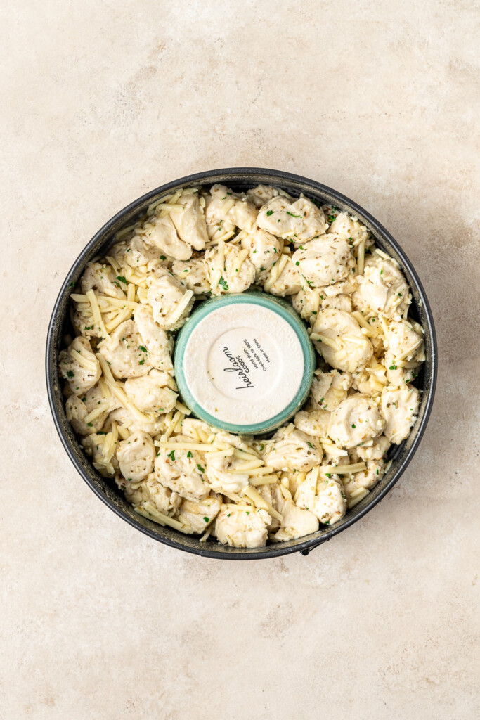 The dough balls and garlic butter in a spring form pan.