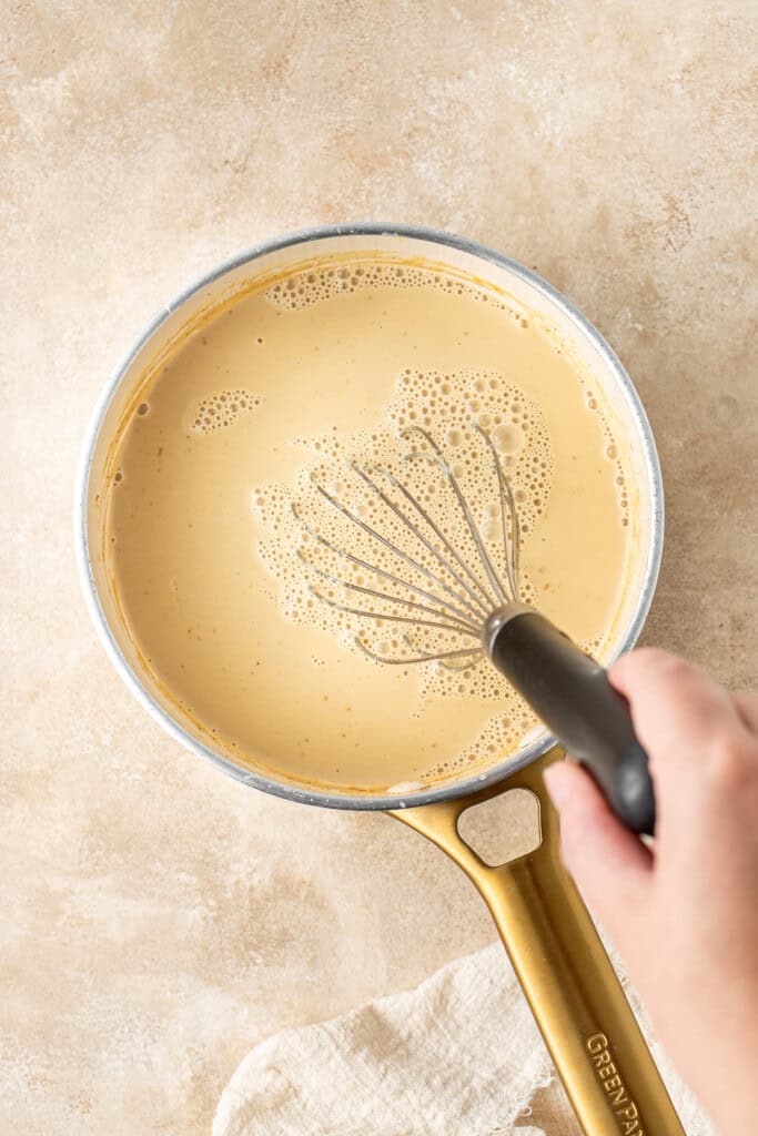 Whisking the eggnog in the saucepan.