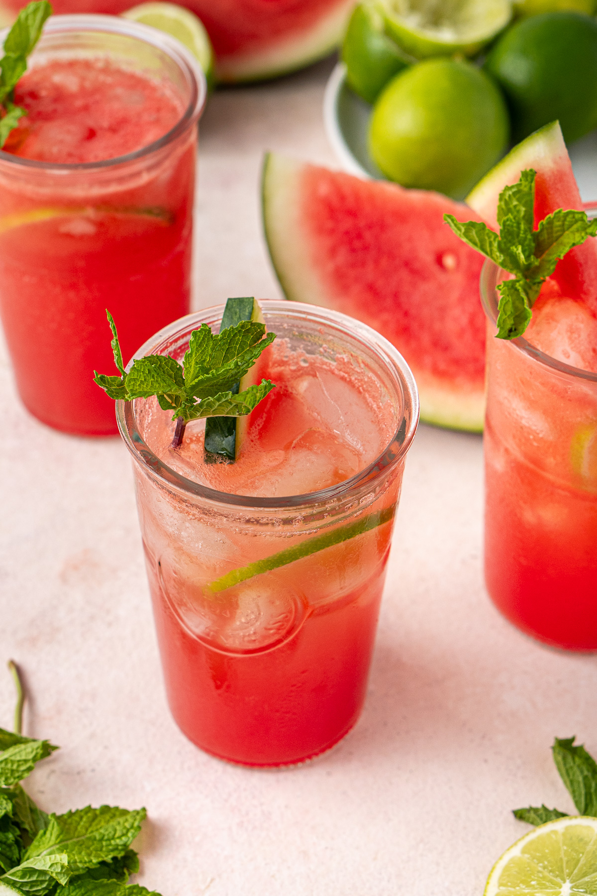 Sparkling watermelon lime mocktails in glasses with fresh mint and lime slices.