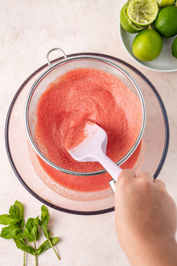 Straining the watermelon juice through a sieve. 