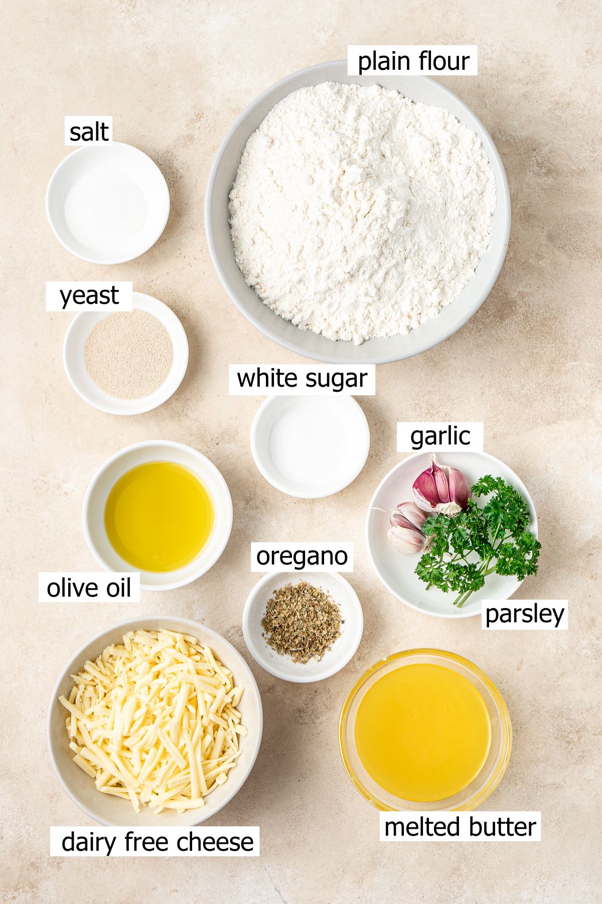 All ingredients needed to make a garlic bread wreath laid out in bowls.