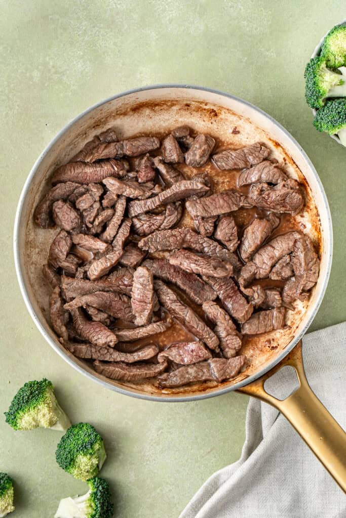 Cooking the beef in a frying pan.