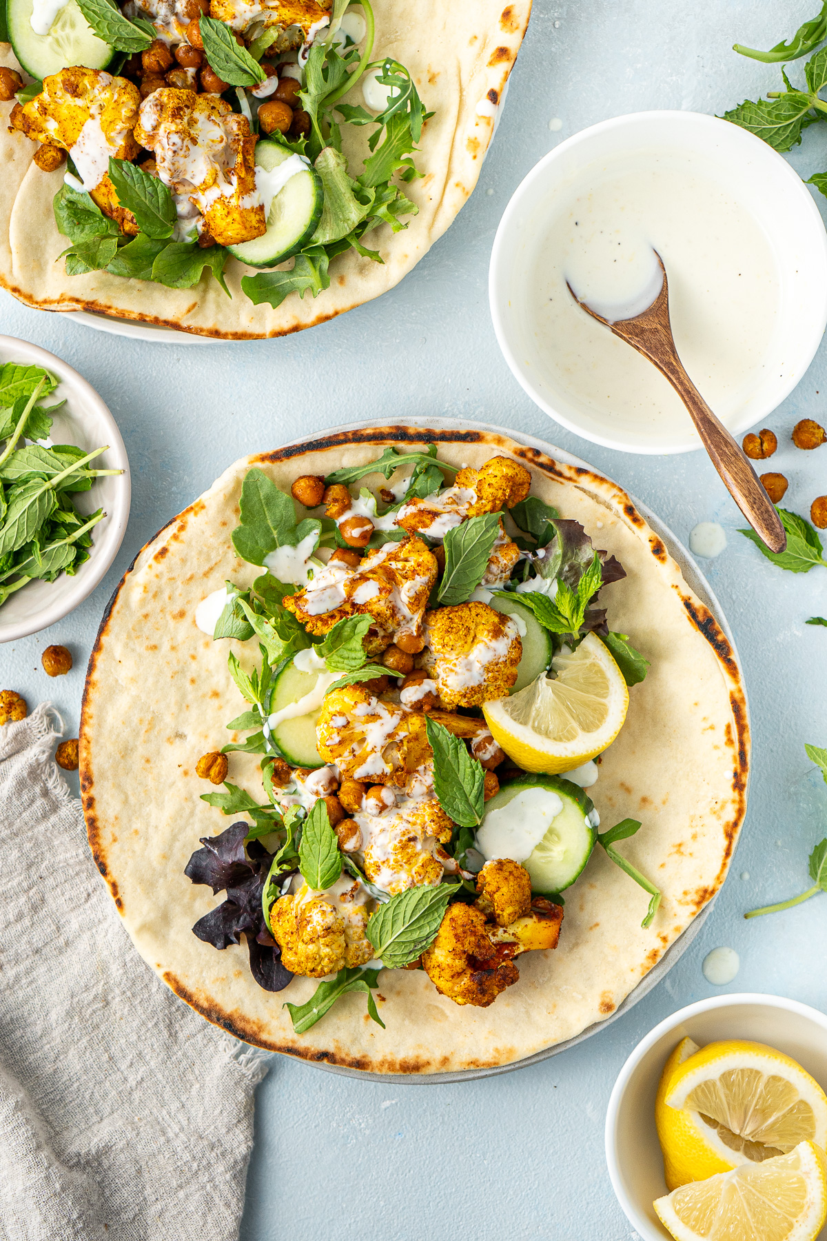 The cauliflower and chickpea shawarmas with a bowl of lemon mayo. 