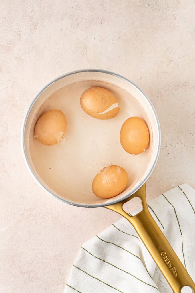 Boiling the eggs in a small saucepan.