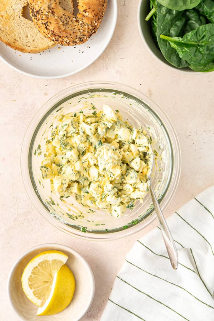 Mixing up the egg salad in a bowl.